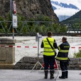 Deux pompiers surveillent le débit du Rhône le samedi 22 juin 2024 entre Sierre et Chippis
